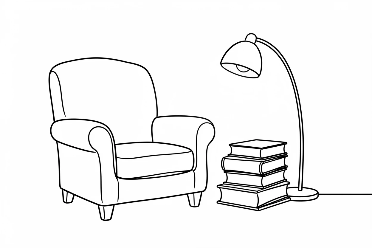 A well-worn armchair beside a stack of books and a glowing reading lamp