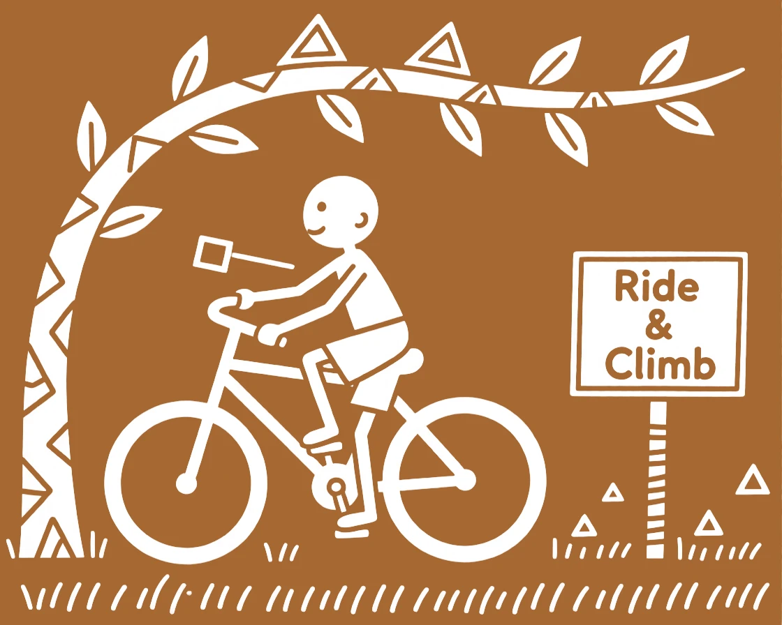 A young boy learning to ride a bicycle climbing a low tree branch for fun.